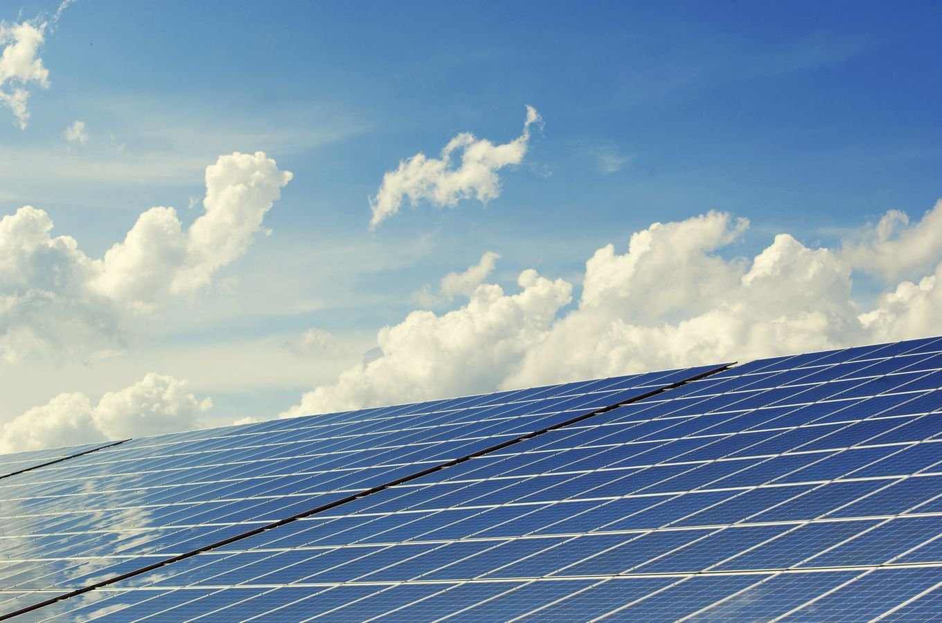 Solar panel array under a vibrant blue sky