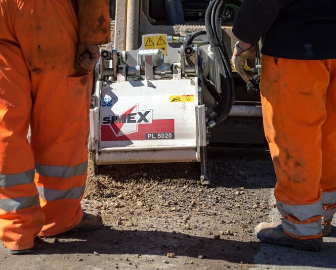 Construction workers laying an asphalt road surface