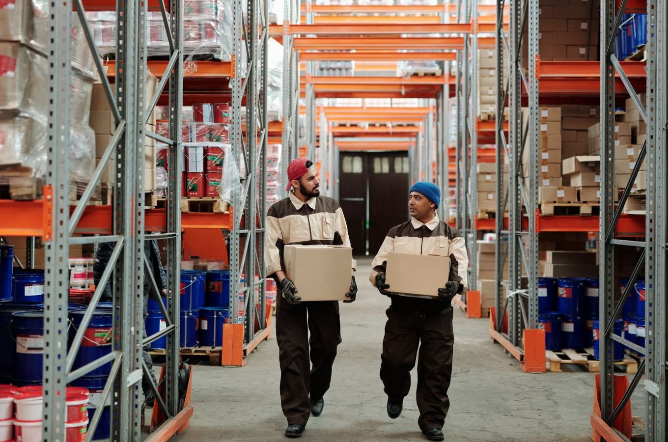 Warehouse workers carrying boxes in a logistics facility