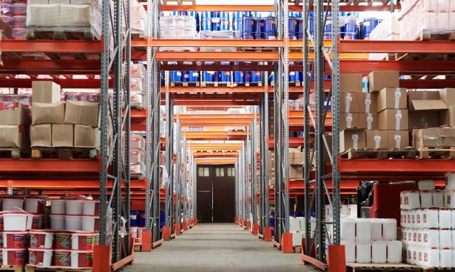 Warehouse with stocked shelves and boxes on concrete floors